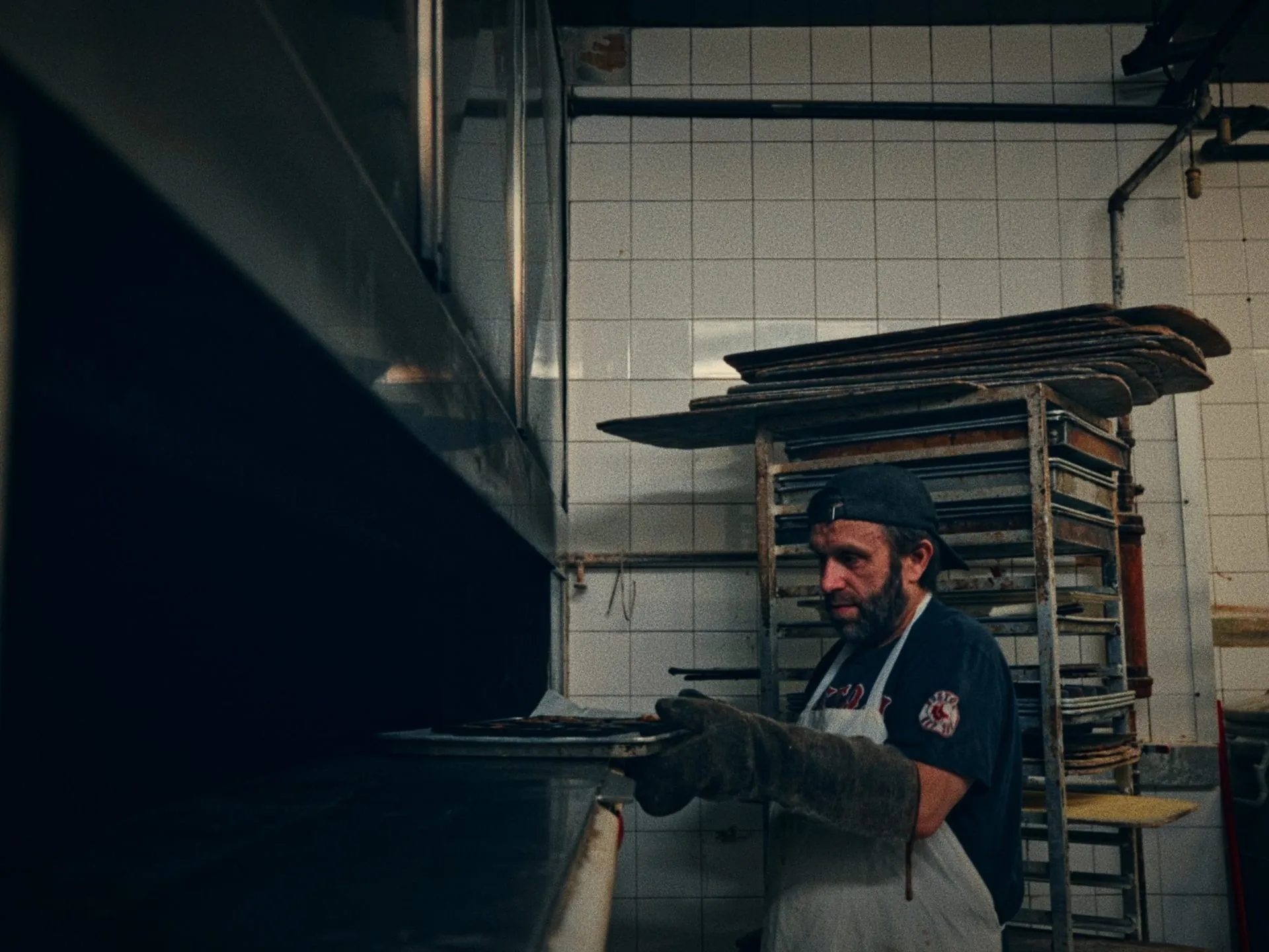 A baker pulling a tray from the oven in the back of house at a Toronto bakery, from Before Thanksgiving by Studio Propel