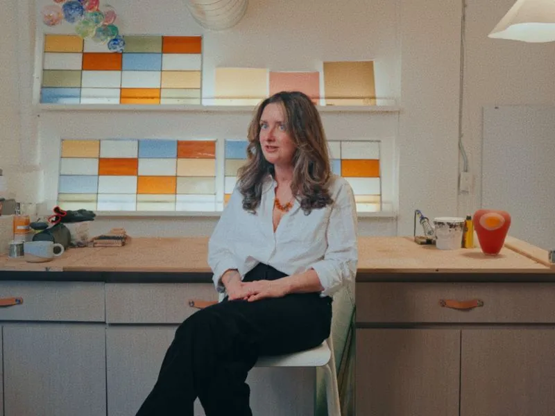 Kristie Urbanski in her studio in front of her stained glass windows, from Art and Motherhood by Studio Propel