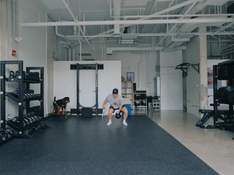 A kettlebell swing in the studio, his dog watching, from Blank Canvas by Studio Propel