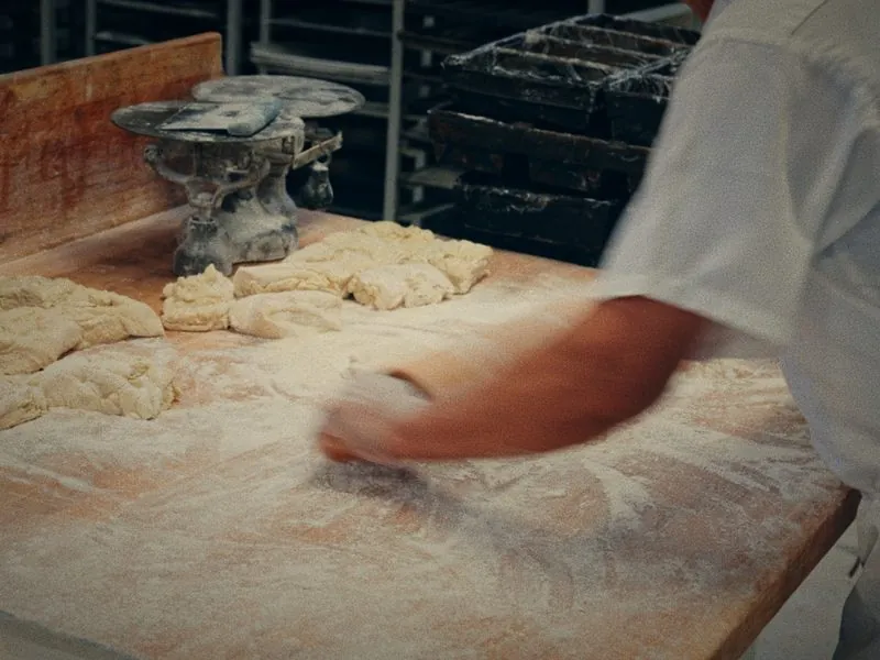 Flour across the bench as dough is divided by hand, from Before Thanksgiving, a Studio Propel short film