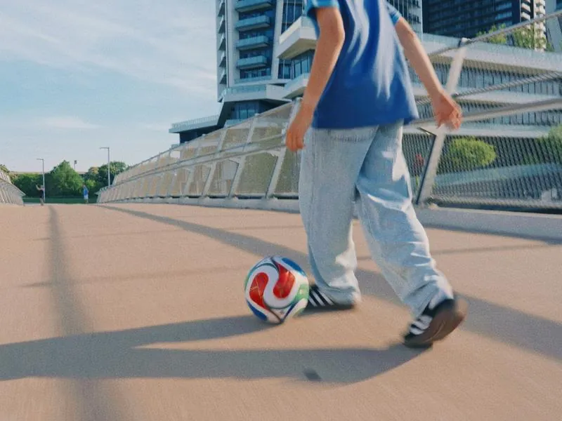 Dribbling across a bridge in the city, from Something Is Coming by Studio Propel