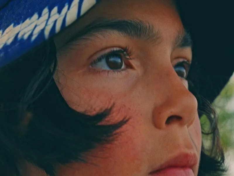 A close-up, eyes on something ahead, from Something Is Coming by Studio Propel