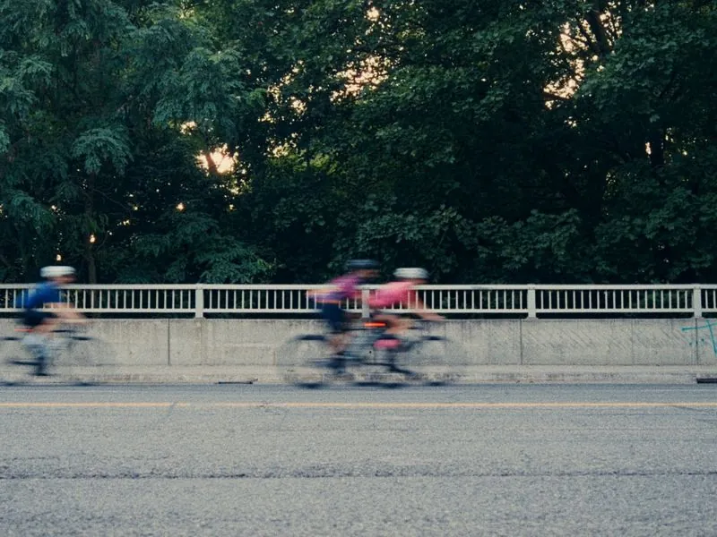 Riders streaking past along the bridge rail, from Morning Ride, an ÜNDA Movement brand film by Studio Propel